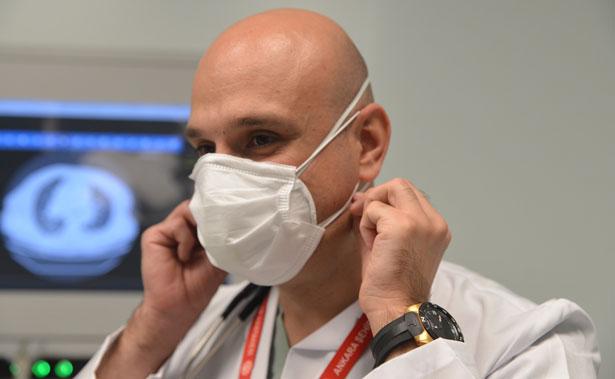 Bilim Kurulu Üyesi, acil serviste N95 üzerine cerrahi maske takıyor